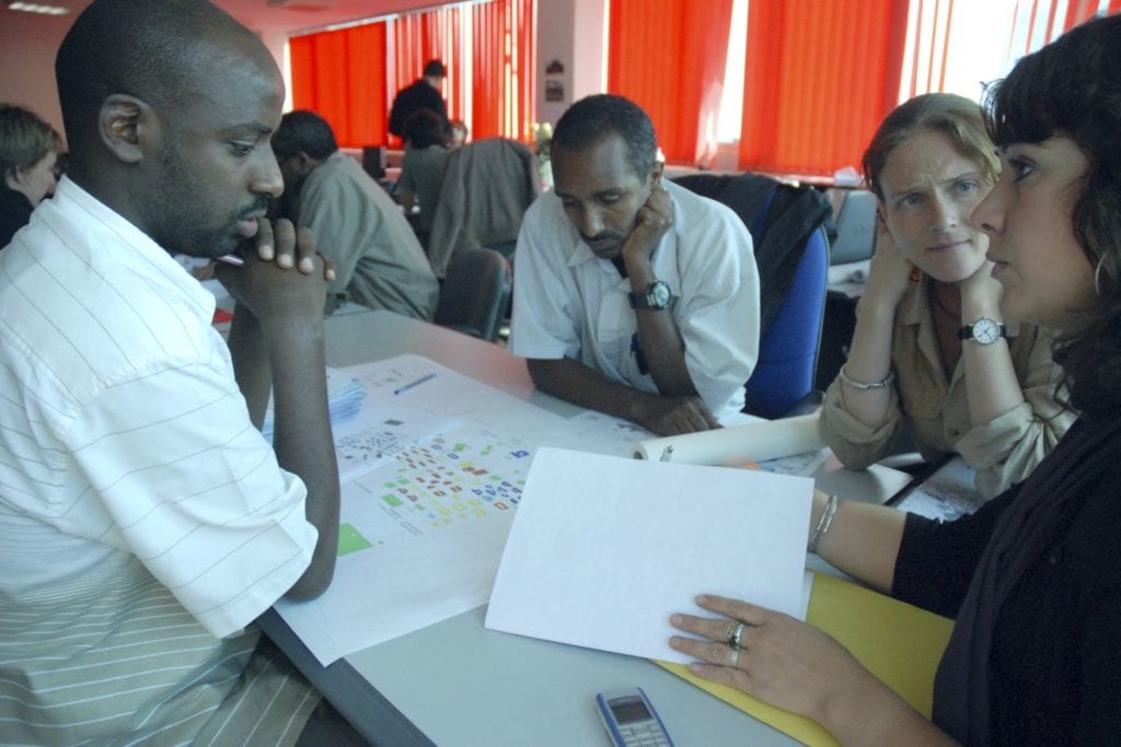 Four people discuss something at a table