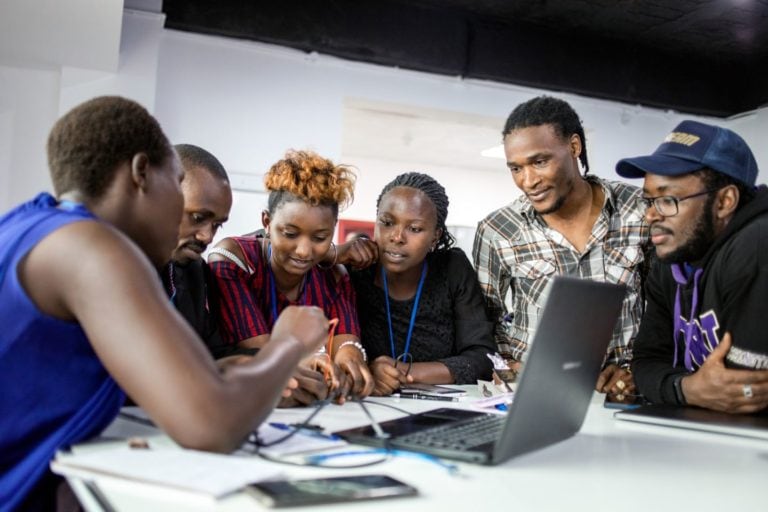 A group of people discussing in front of a computer