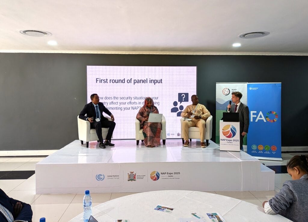 Three people hold a panel discussion with a moderator.
